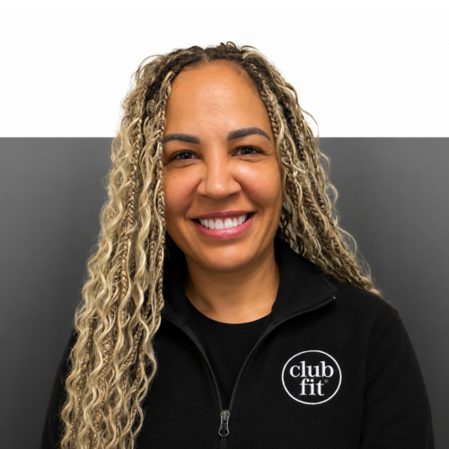 Women with long hair smiles infront of half grey half white background, wearing club fit jacket.